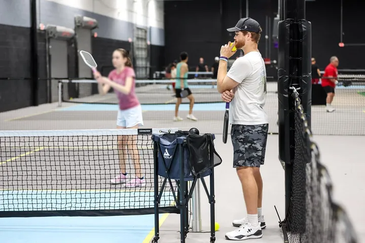Tanner Rice watching a student hit during a lesson